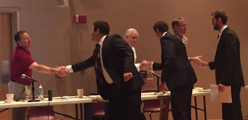 men shaking hands at community outreach event